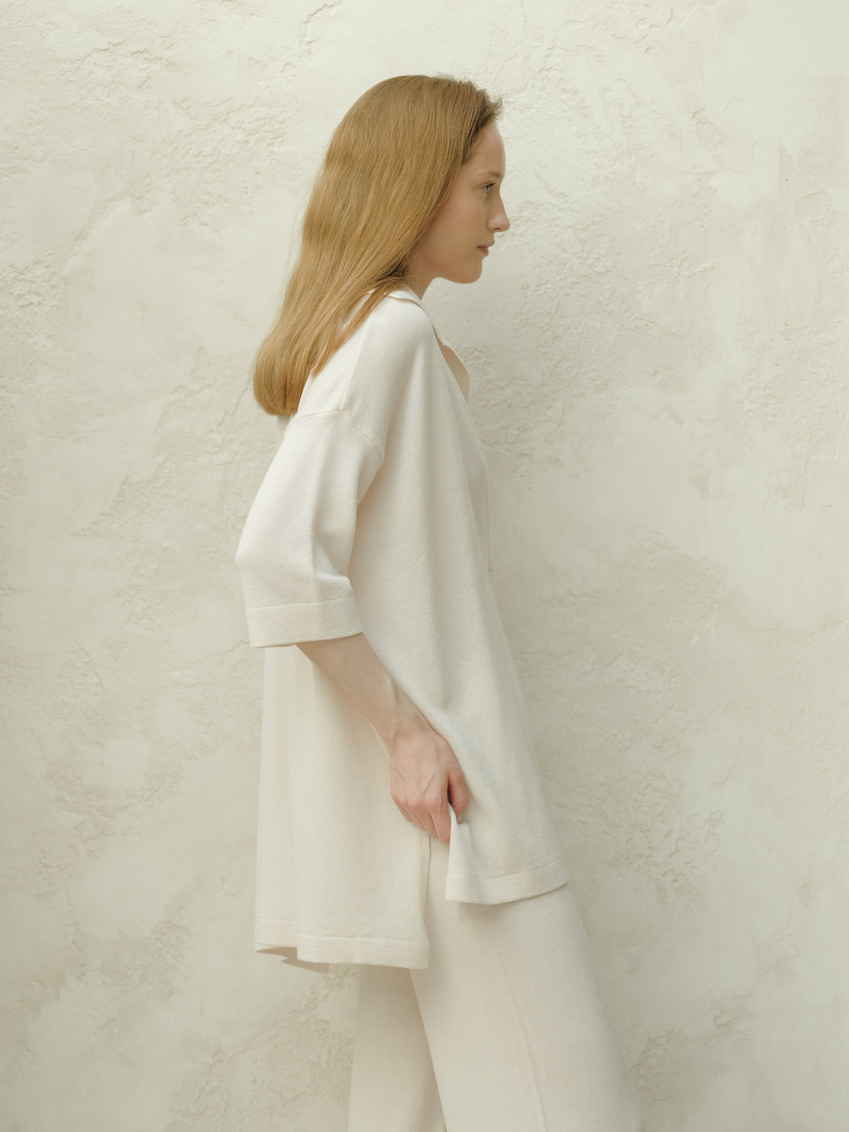 Side profile of a modelo con an oversized off white Maxi polo de lana merina extrafina with three quarter sleeves.