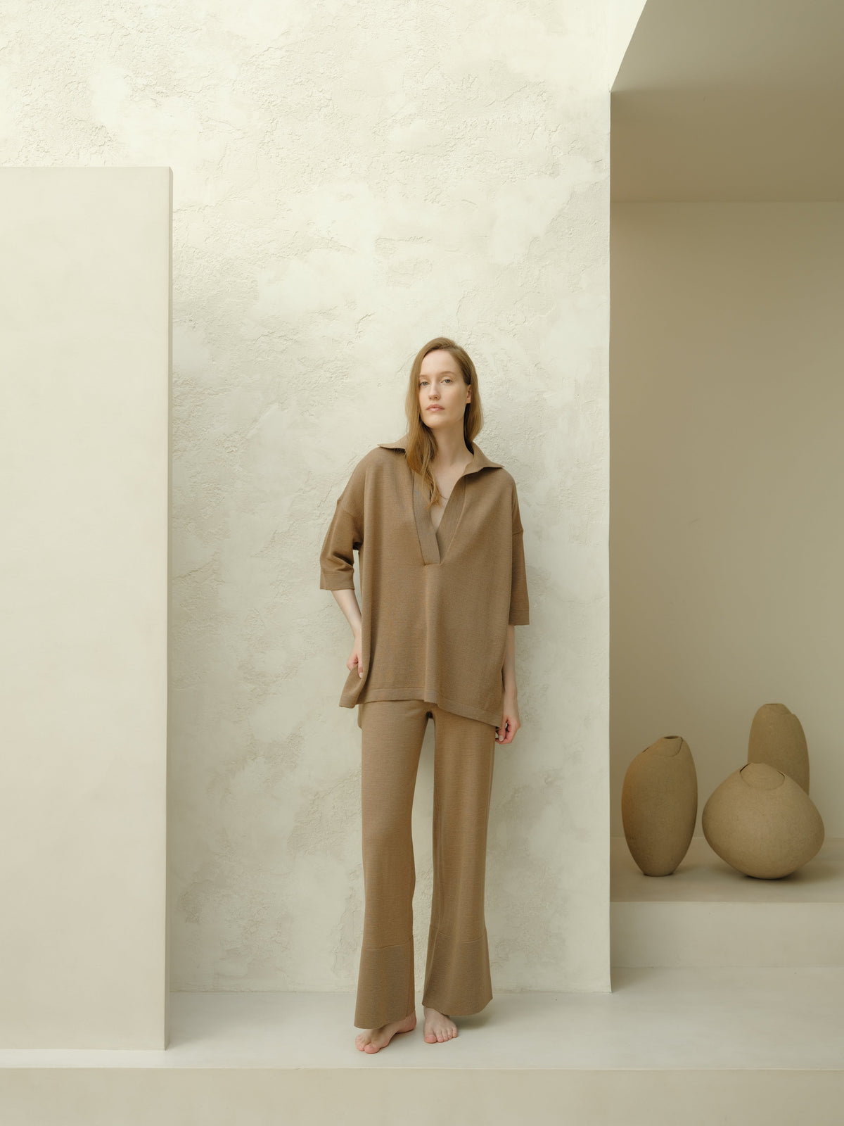 Modelo con taupe Maxi polo de lana merina extrafina set with an oversized top featuring three-quarter sleeves and pantalones de pierna ancha.
