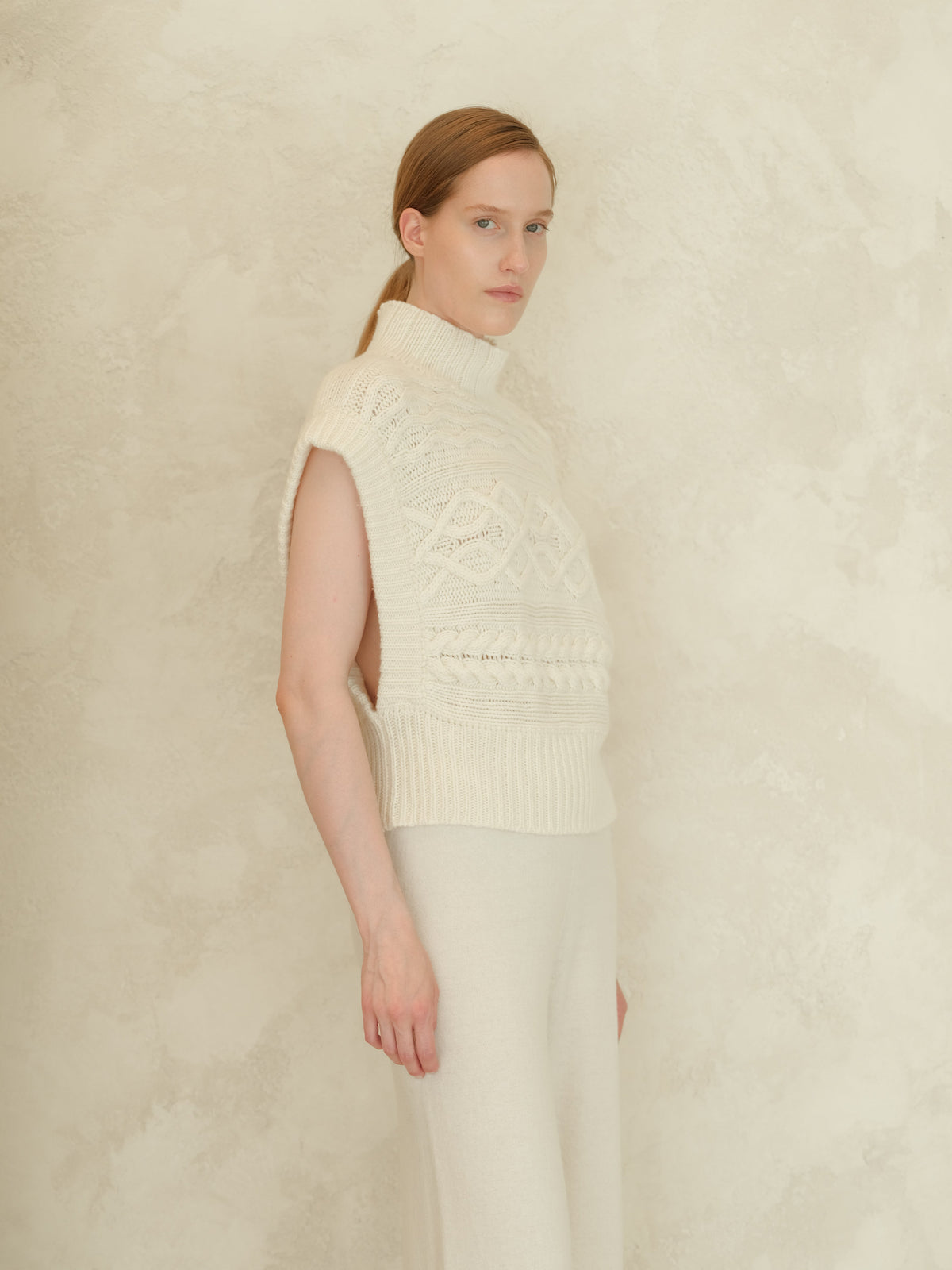 Model in ivory cashmere mix Maxi-Zopfstricktunika featuring a hoher Kragen and bold cable patterns.
