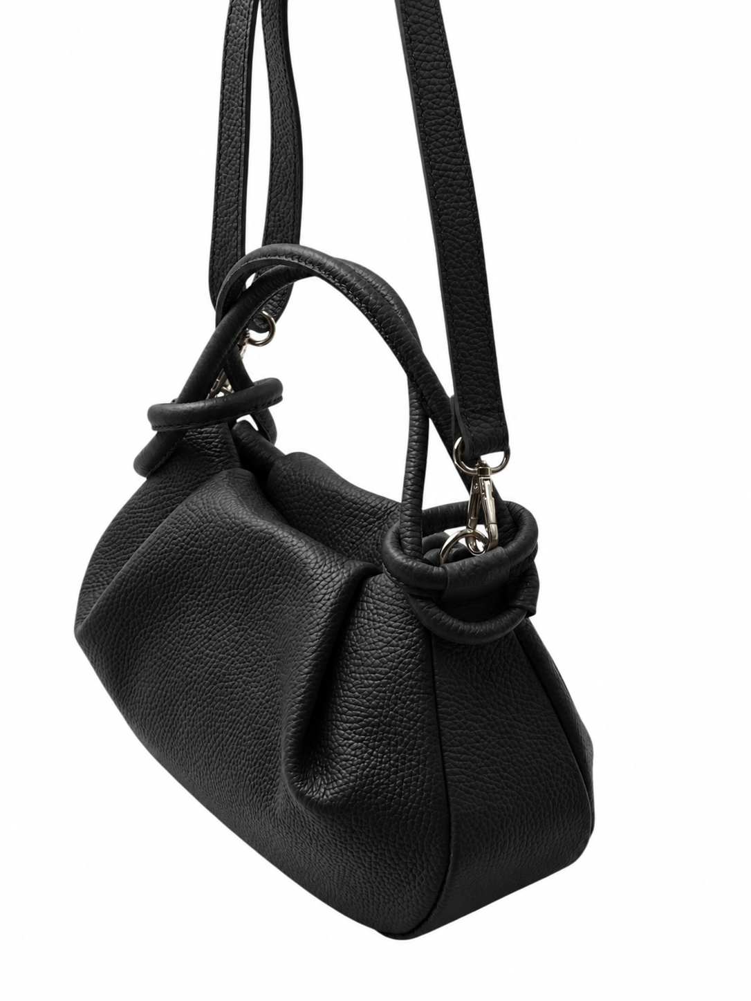 Bolso de piel granulada negra con silueta fruncida y flexible, dos asas y correa de hombro desmontable sobre fondo blanco.