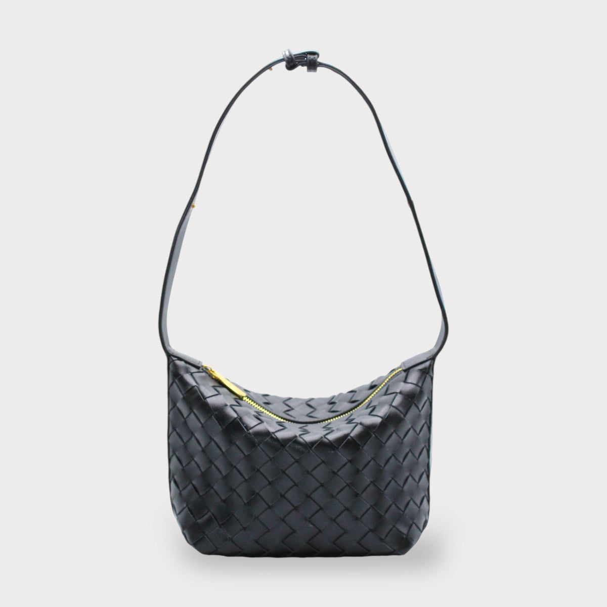Noir woven leather shoulder bag with a long strap and gold zipper.