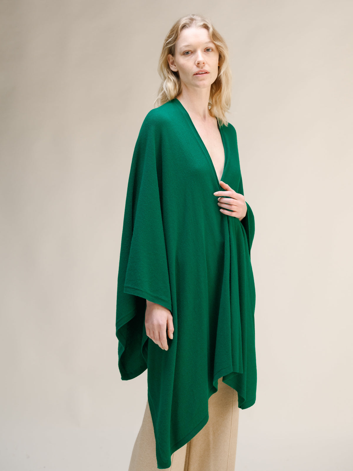 Modelo con capa maxi verde esmeralda de mezcla de cachemira con frontal cruzado sobre pantalón beige