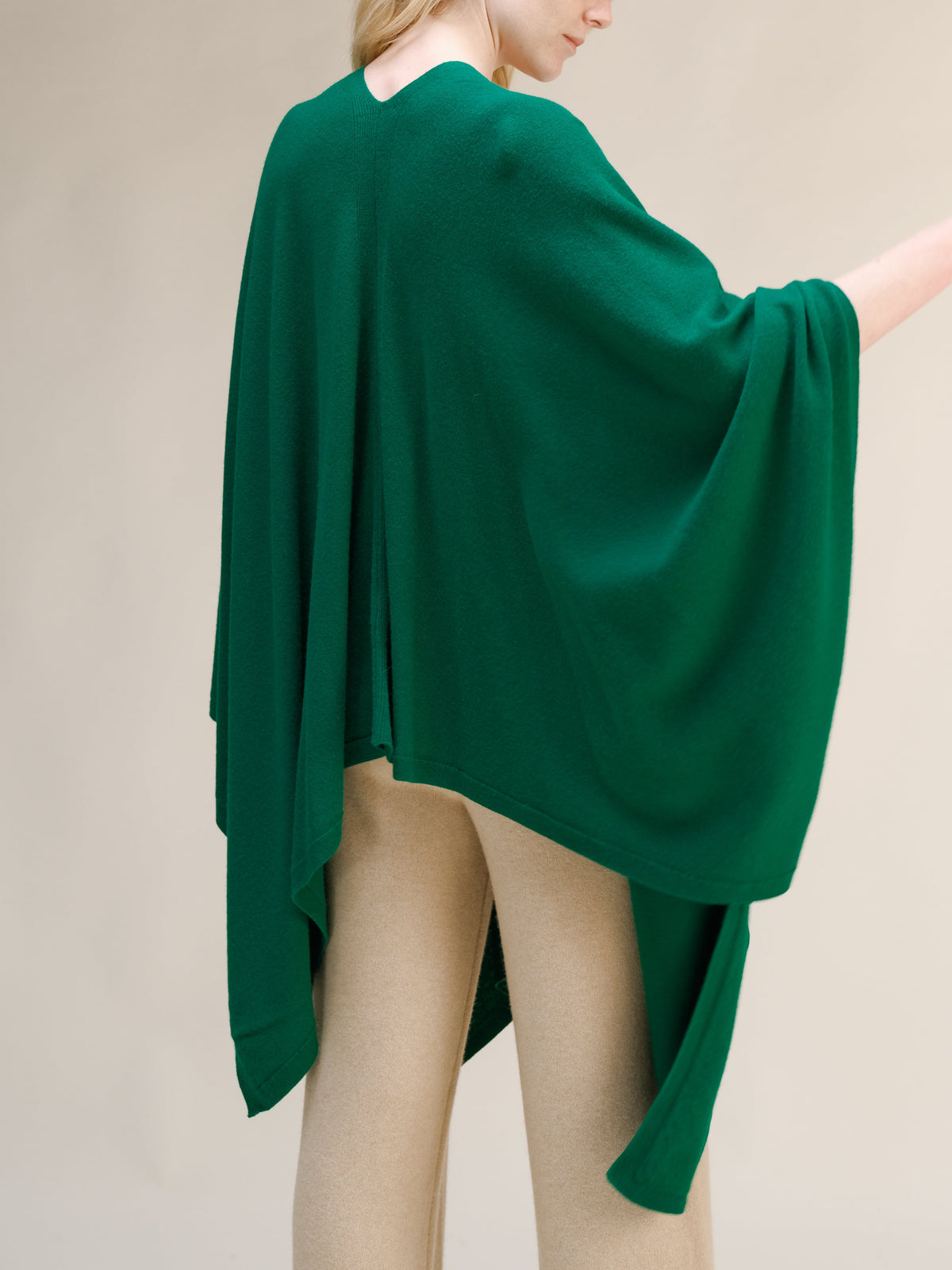 Verde cashmere mix maxi cape draped over a model from the back, with beige pants visible.