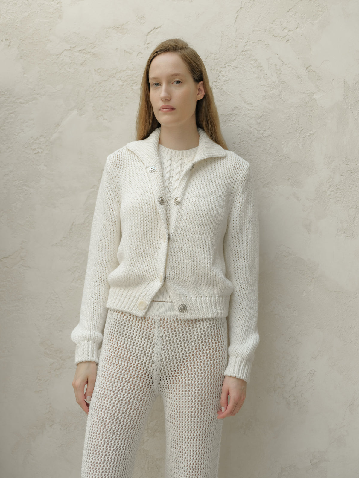 Vista frontale of a modella con a bianco texturosso knit bomber jacket con a collar e metal buttons.