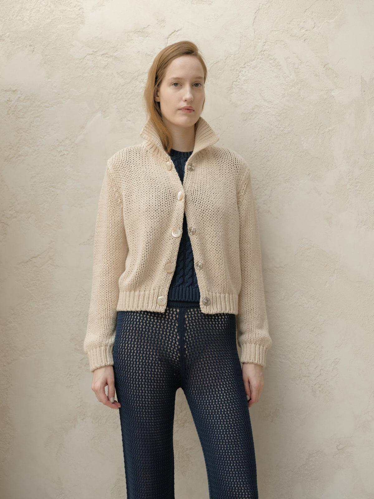 Bomber beige in maglia grossa con grandi bottoni e collo alto indossato frontalmente da una modella