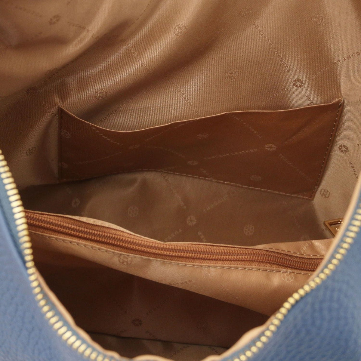 Cuero interior with curved brown bolsillo abierto and forro con estampado de logo inside the bag