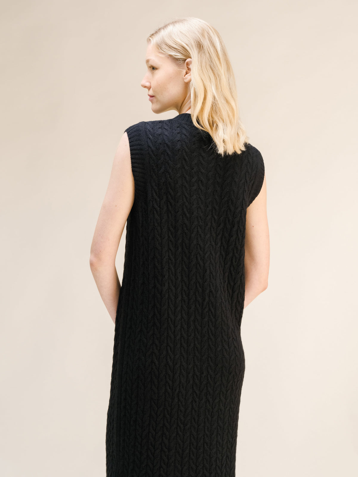 Black Wool & Cashmere Mix Sleeveless Cable Knit Dress featuring a textured cable pattern and a high neckline viewed from the back.