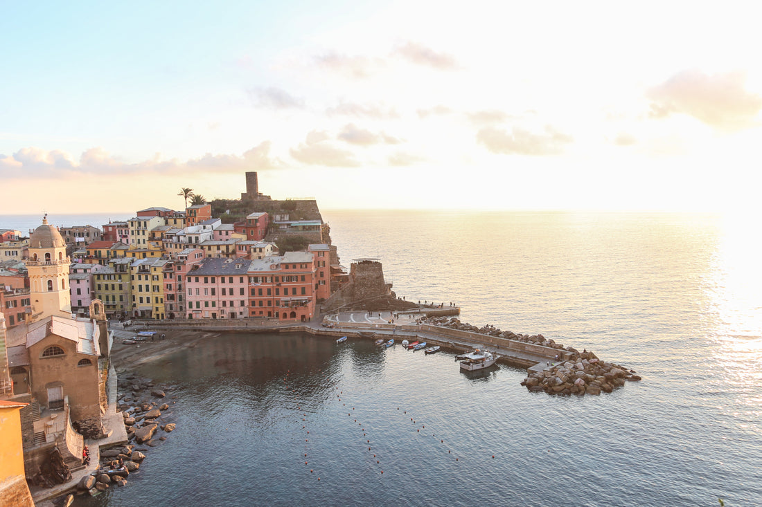 Vue au coucher du soleil sur un village côtier italien coloré avec un port et des bateaux.