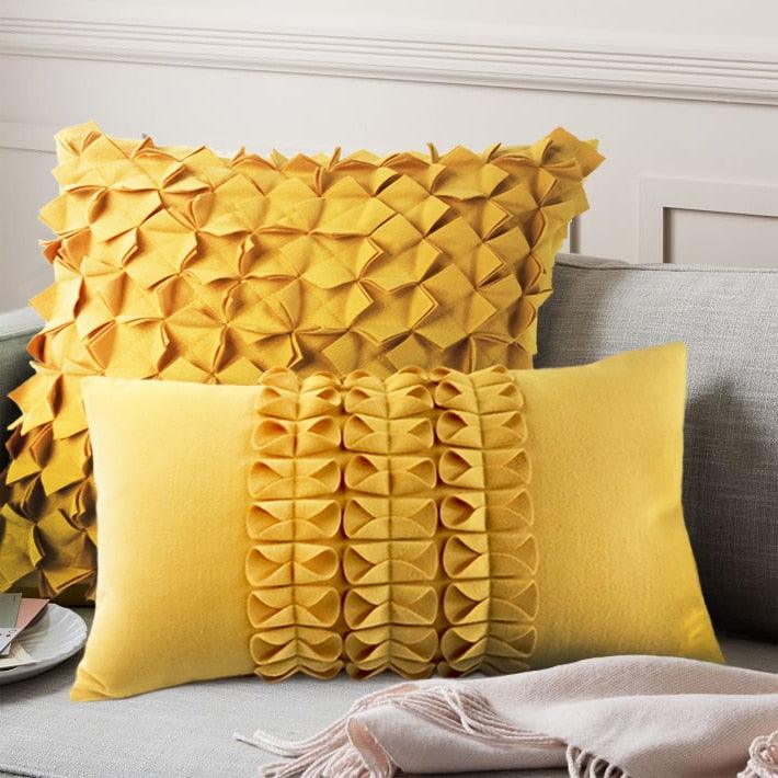 Yellow decorative pillows with geometric pleats on a gray sofa