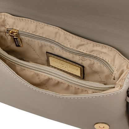 Close-up of a beige handbag interior showing a zippered pocket with a gold-tone metal zipper pull and a gold-tone brand plaque reading 'TUSCANY LEATHER'.