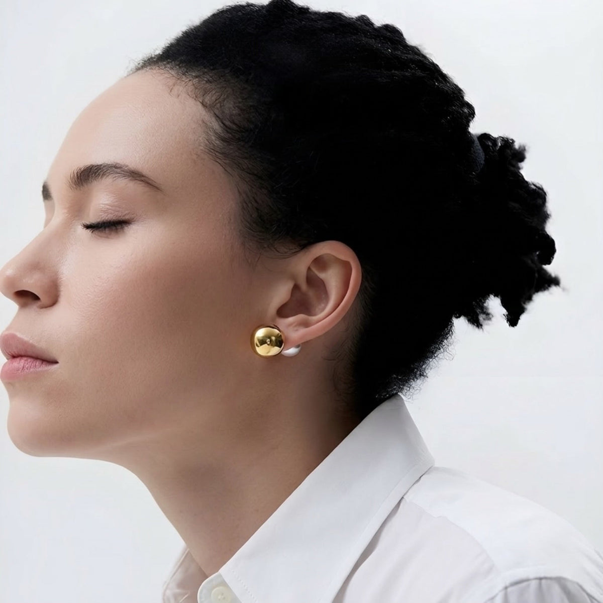 Mujer con gold earrings with a pearl back sobre fondo blanco