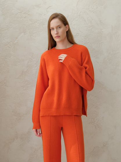 Front view of a modelo con an orange cashmere mix crewneck ribbed sweater with a corte relajado