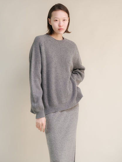 Modelo con gray ribbed cashmere mix jersey de cuello redondo with corte relajado and a matching knit skirt.