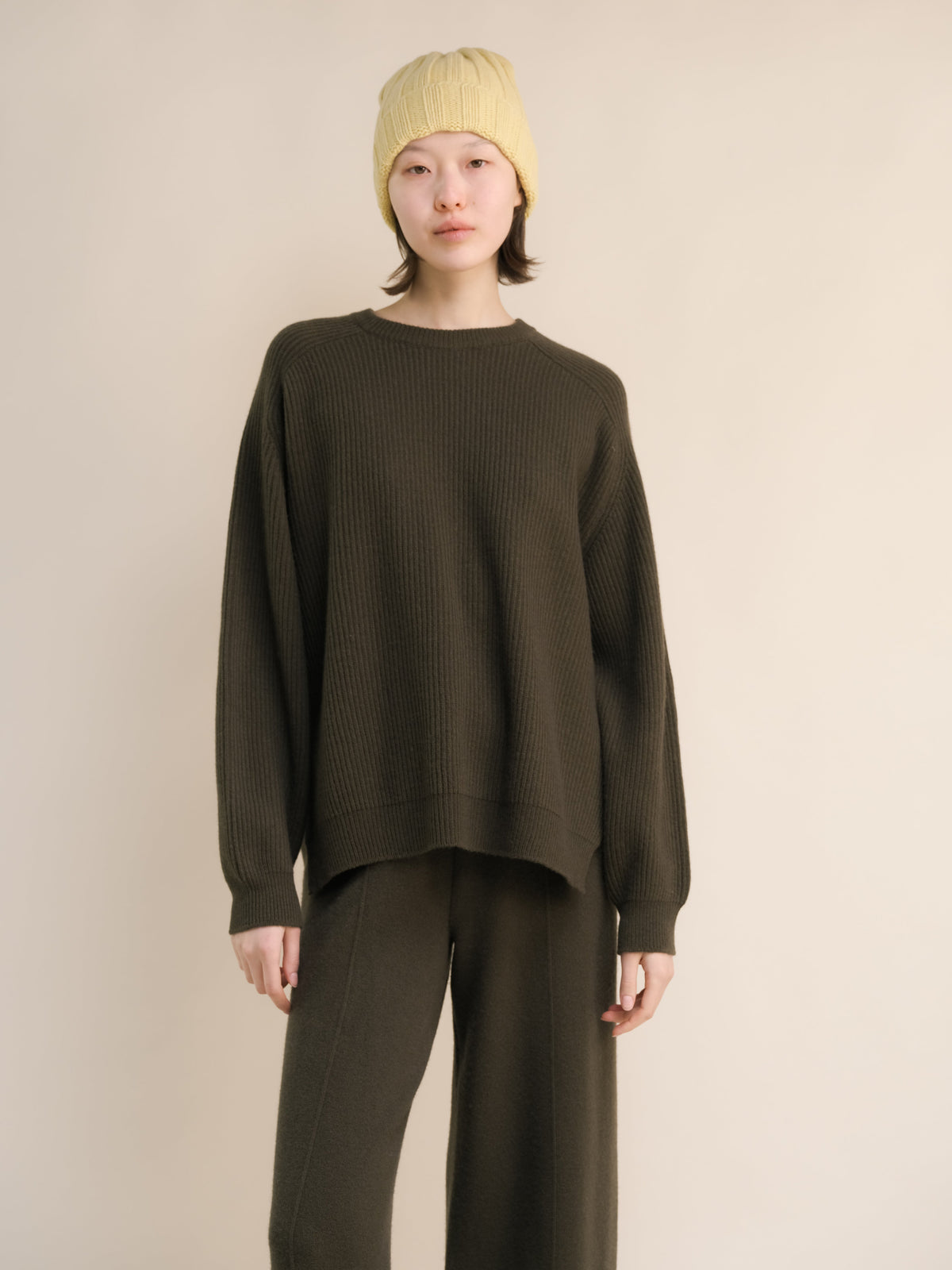Modelo con olive ribbed cashmere mix crewneck with lateral slits and a yellow knit beanie