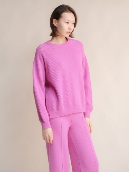 Modelo con a pink cashmere mix crewneck ribbed sweater with side slits and matching pink pants