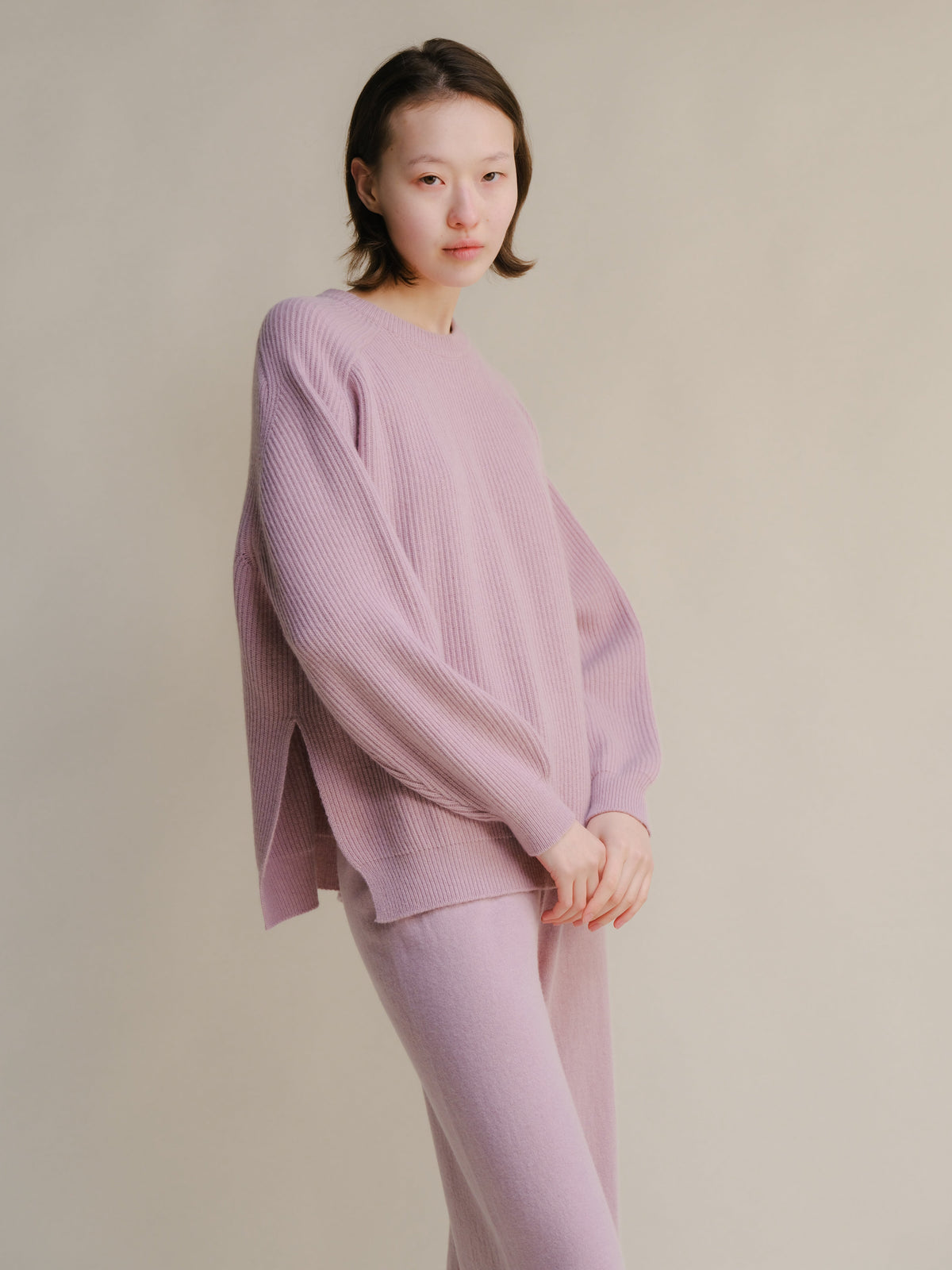Modelo con soft lavender ribbed cashmere mix jersey de cuello redondo with side slits and pantalones a juego