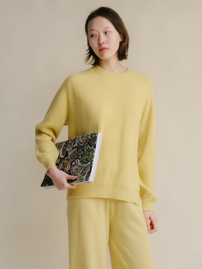Modelo con pale yellow cashmere mix crewneck ribbed sweater with side slits, paired with matching knit pants