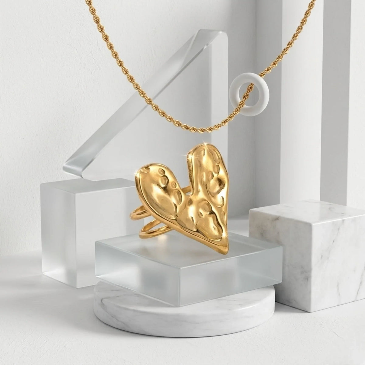 Gold necklace with a unique heart ring on a white background