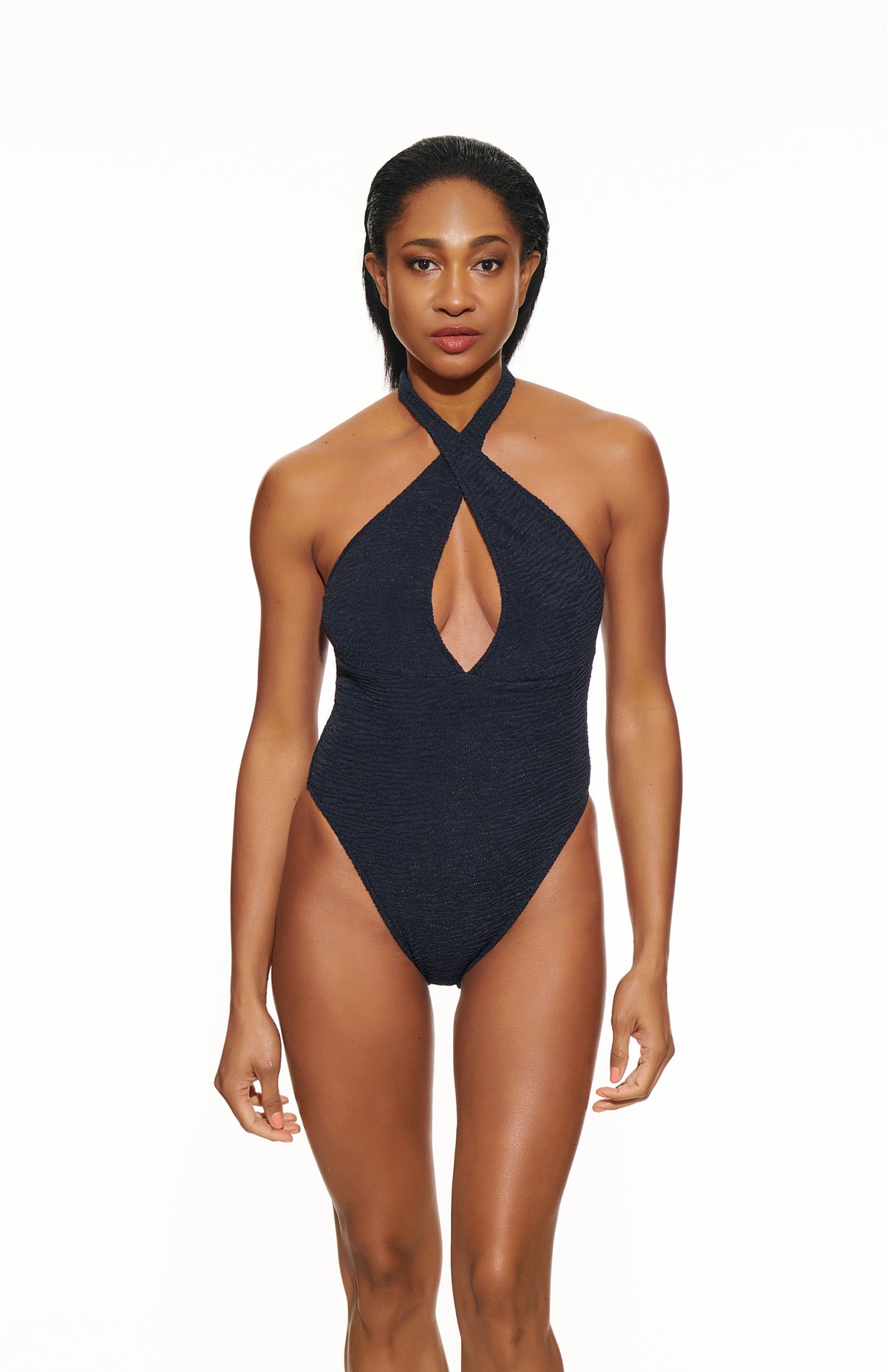 Woman wearing a black halter neck swimsuit on a white background