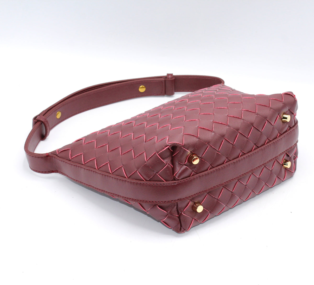 Genuine leather woven boxed pouch bag in burgundy with gold studs and a long shoulder strap.