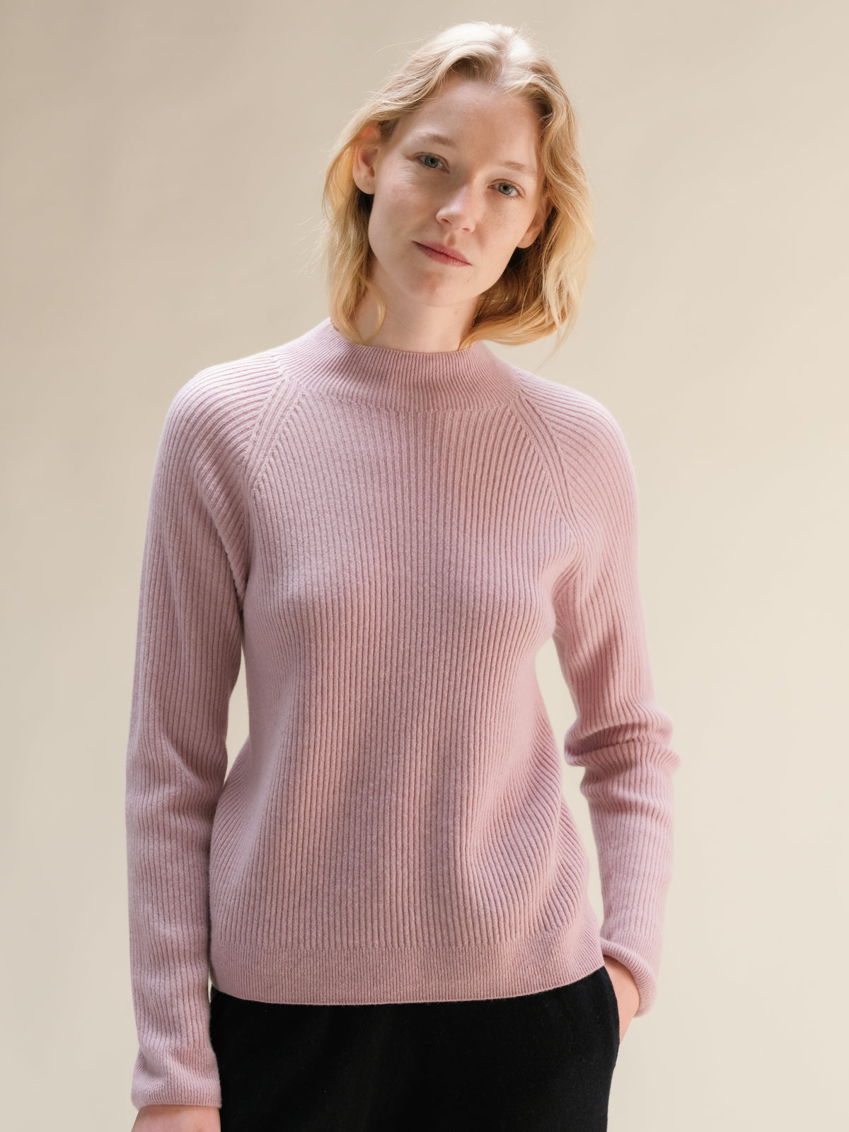 Soft pink cashmere mix ribbed mock neck sweater on a model.
