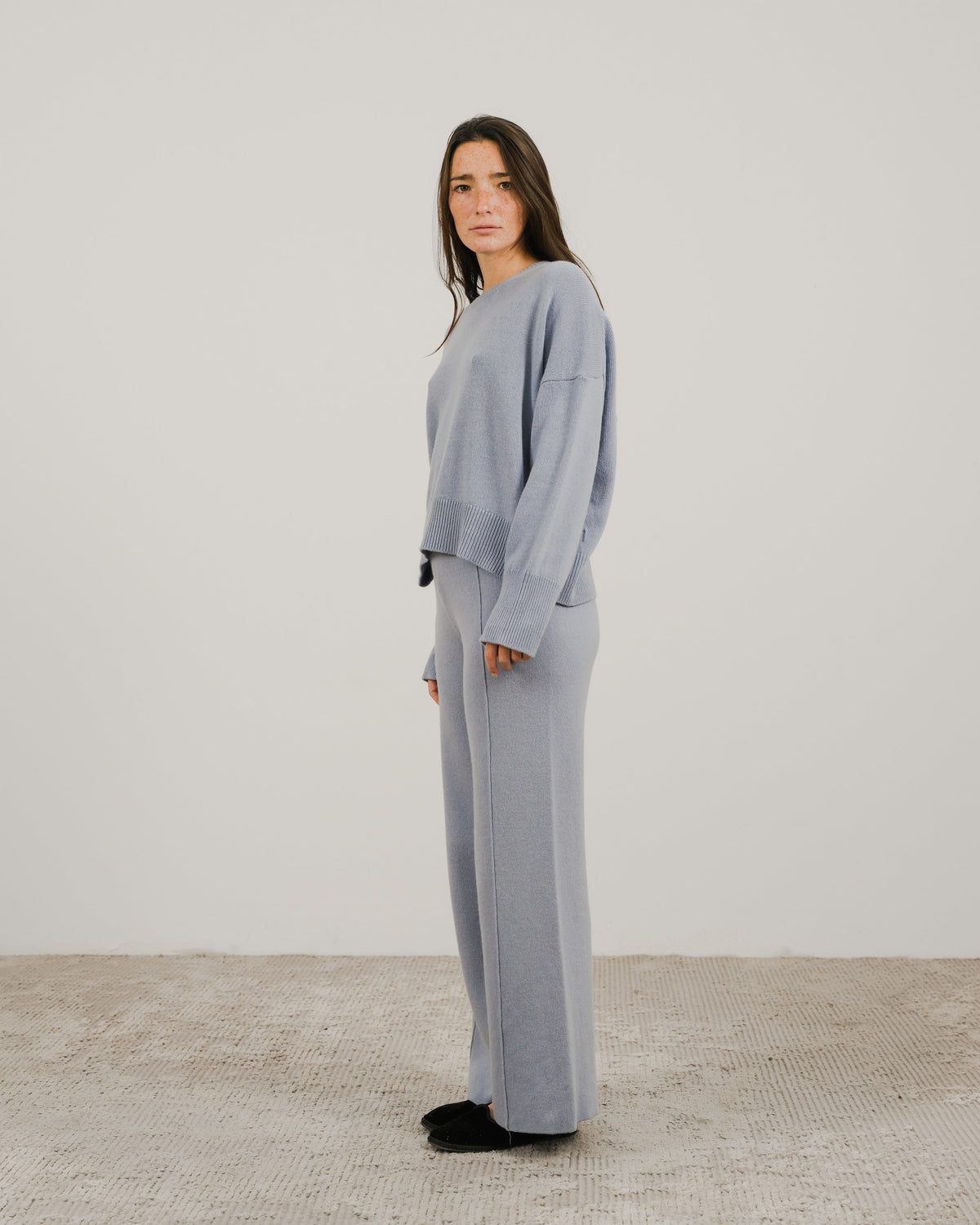 Light blue oversized cashmere mix crewneck sweater worn by a model in a side pose.