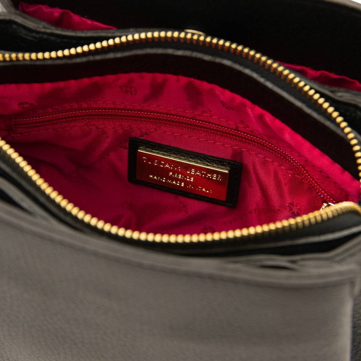 Innenraum der Abby Tasche mit rotem Futter und goldfarbener Markenplakette