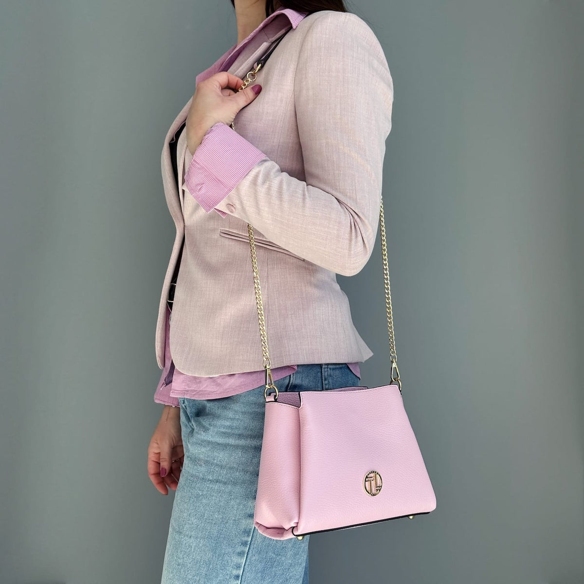Rosa leather Abby shoulder bag with gold chain strap worn crossbody.