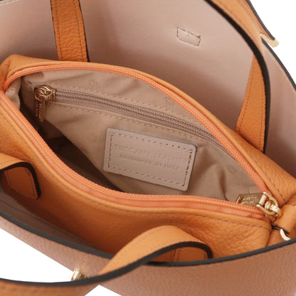 Open view of tan leather tote purse showing soft beige interior lining and zippered pocket with leather label inside