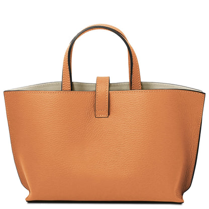 Tan full-grain leather tote bag with pebbled texture, short handles, and simple tab closure, crafted in Italian leather.