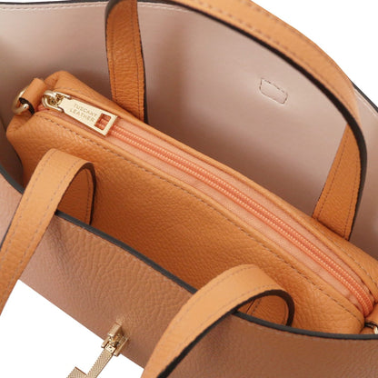 Top view of tan pebbled leather tote bag showing zipped inner pouch with gold-tone hardware and smooth beige lining.
