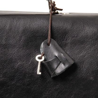Alessandria mat leer laptop briefcase close-up with a leather tag and key on a brown cord