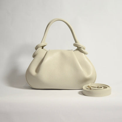 Beige handbag with matching strap on a light gray background