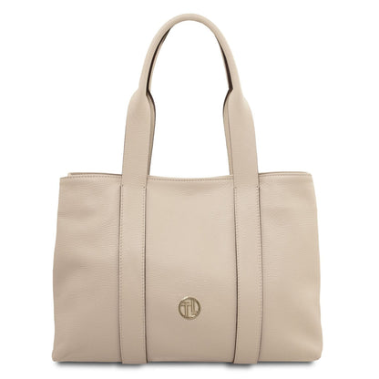 Beige piel suave shoulder bag with two handles and a small emblema de logo dorado on the front
