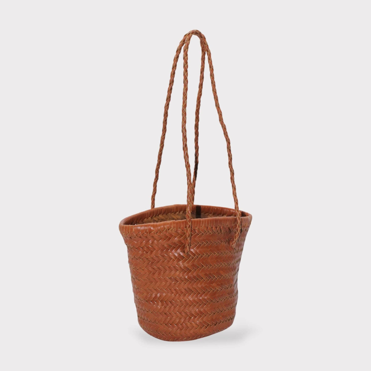 Carmel hand woven brown leather shoulder bucket bag shown in vista lateral with braided handles.