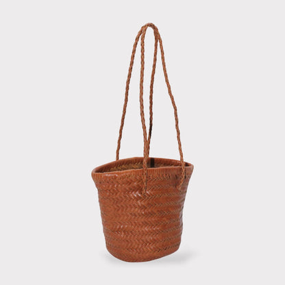 Carmel hand woven brown leather shoulder bucket bag shown in vista lateral with braided handles.