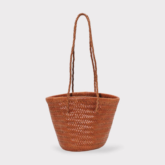 Carmel hand woven brown leather shoulder bucket bag with braided handles on a clean white background.