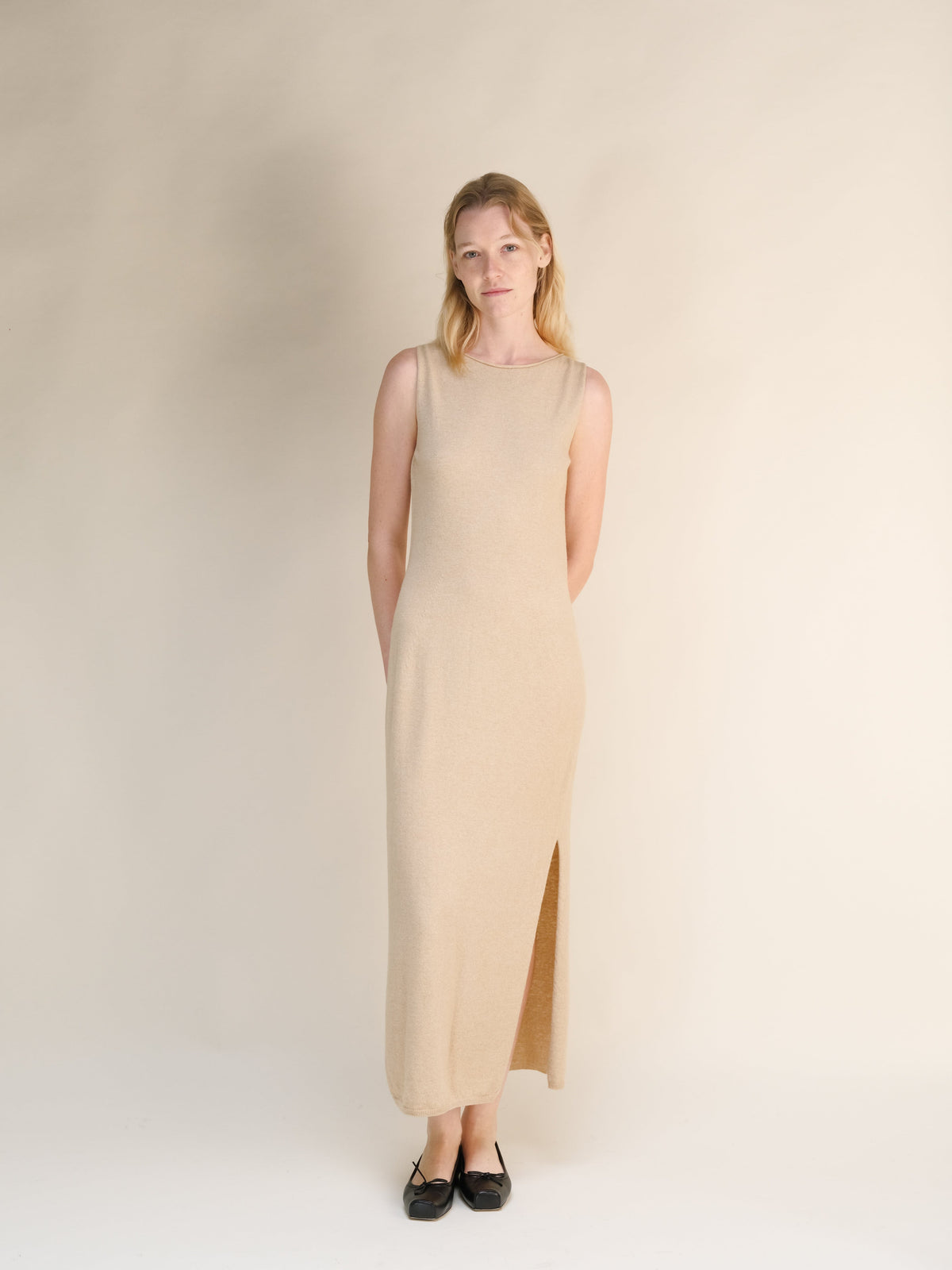 Beige cashmere blend boat neck sleeveless dress indossata da una modella, full-length knit gown