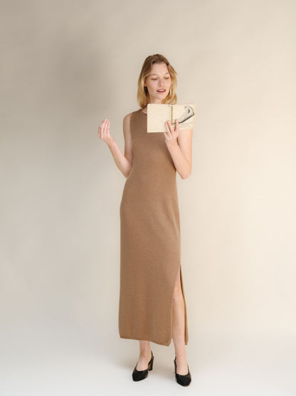 Full-length modella con a taupe cashmere blend boat neck sleeveless dress e reading a book