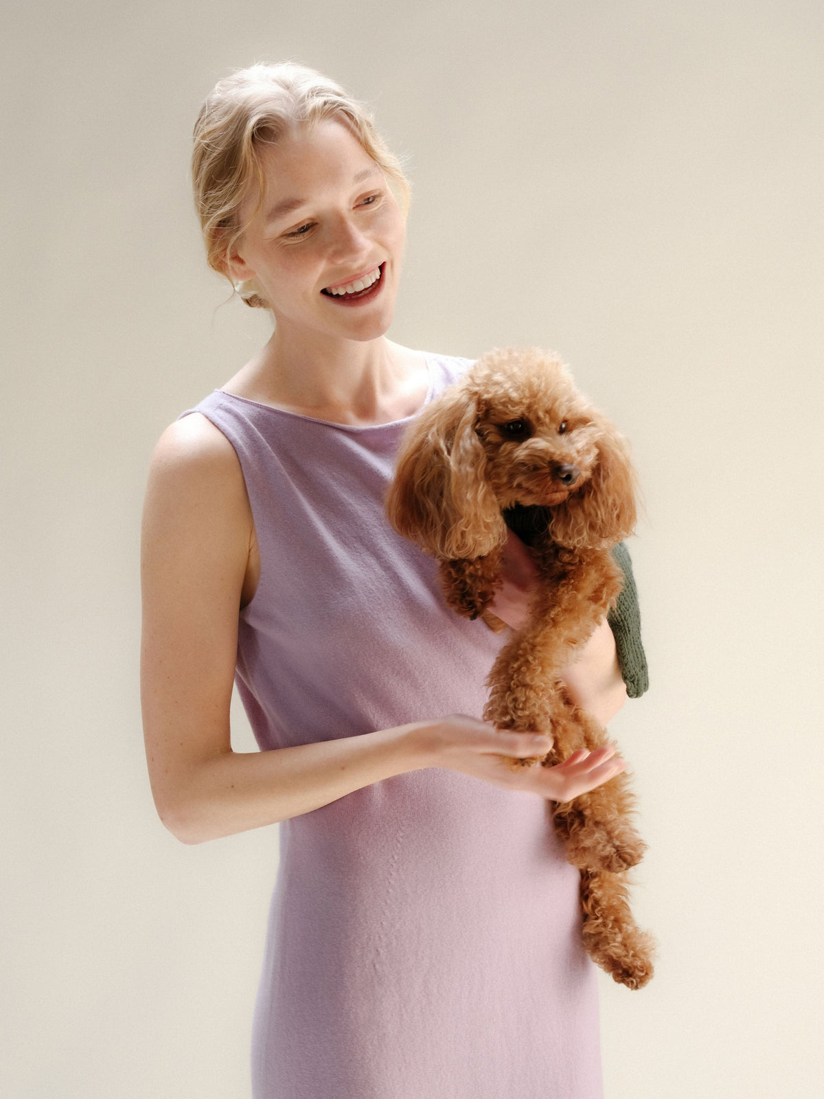 Modella con lavea cashmere blend boat neck sleeveless dress holding a small marrone poodle
