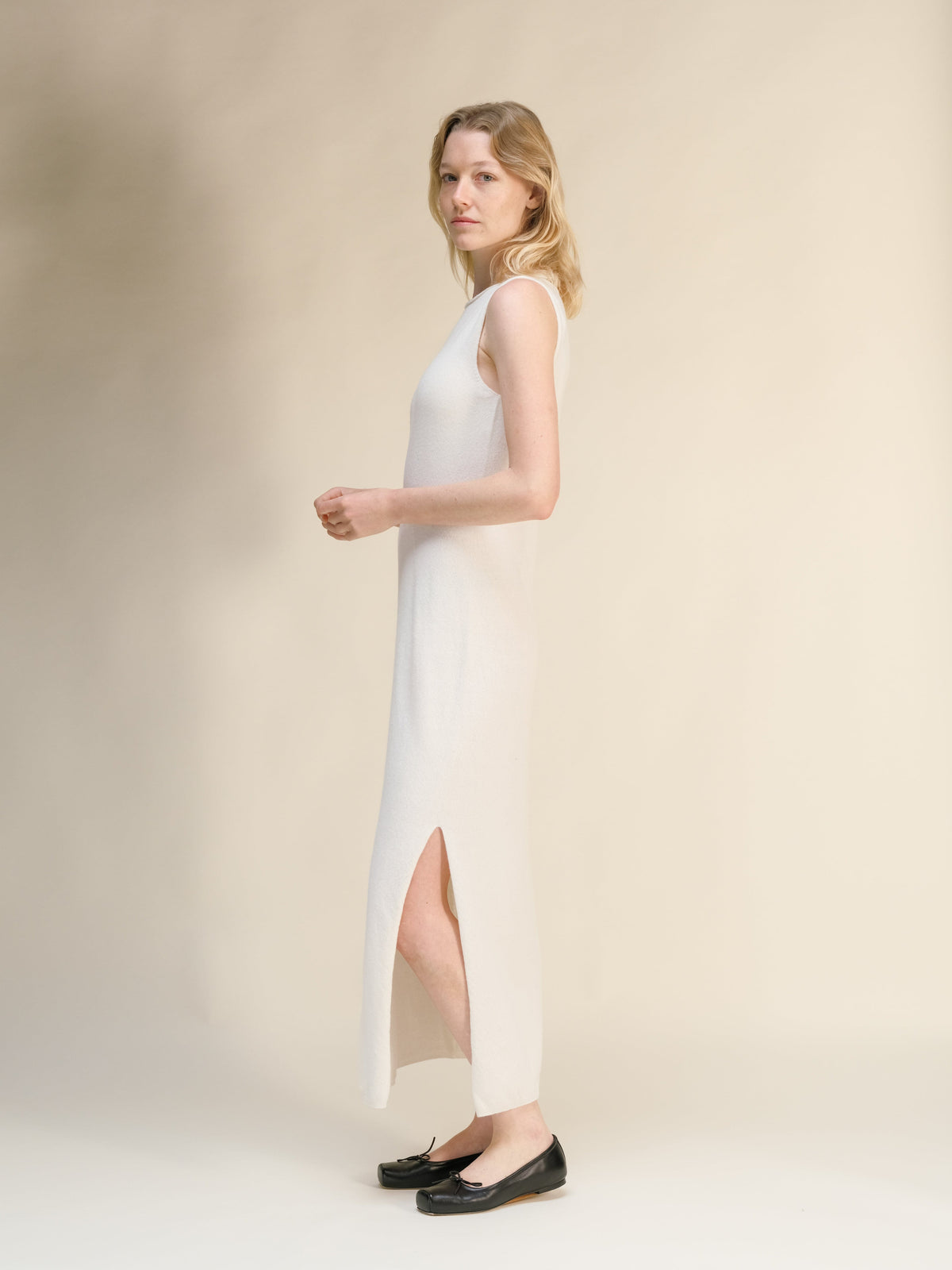 Bianco cashmere blend boat neck sleeveless maxi dress shown in profile on a model