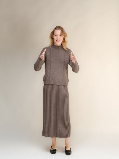Model wearing a taupe cashmere blend knit sweater and matching long ribbed skirt.