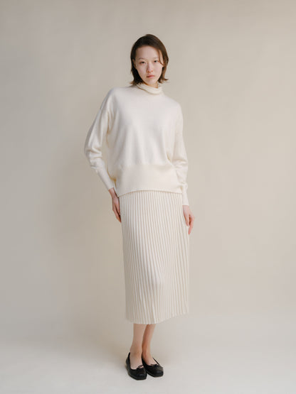 Cream turtleneck knit sweater with a matching ribbed midi skirt.
