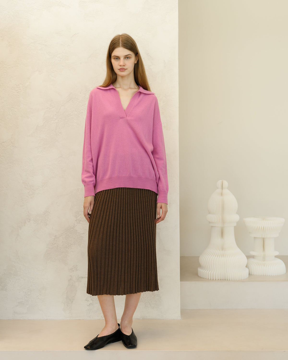Model wearing pink oversized cashmere blend sweater paired with a brown ribbed midi skirt and black flats.