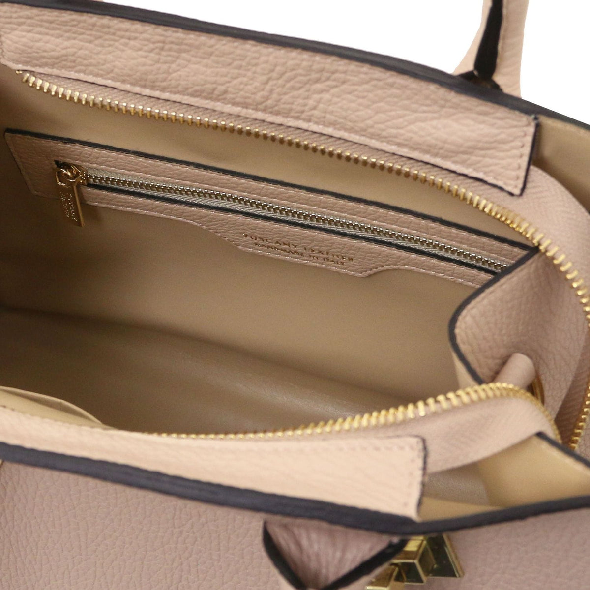 Interior of blush pink pebbled leather tote with zippered pocket and beige lining