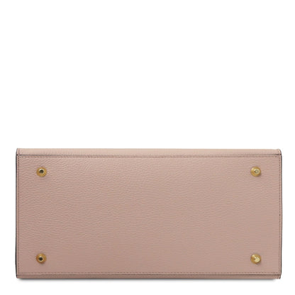 Bottom view of blush pink pebbled leather tote with four gold feet