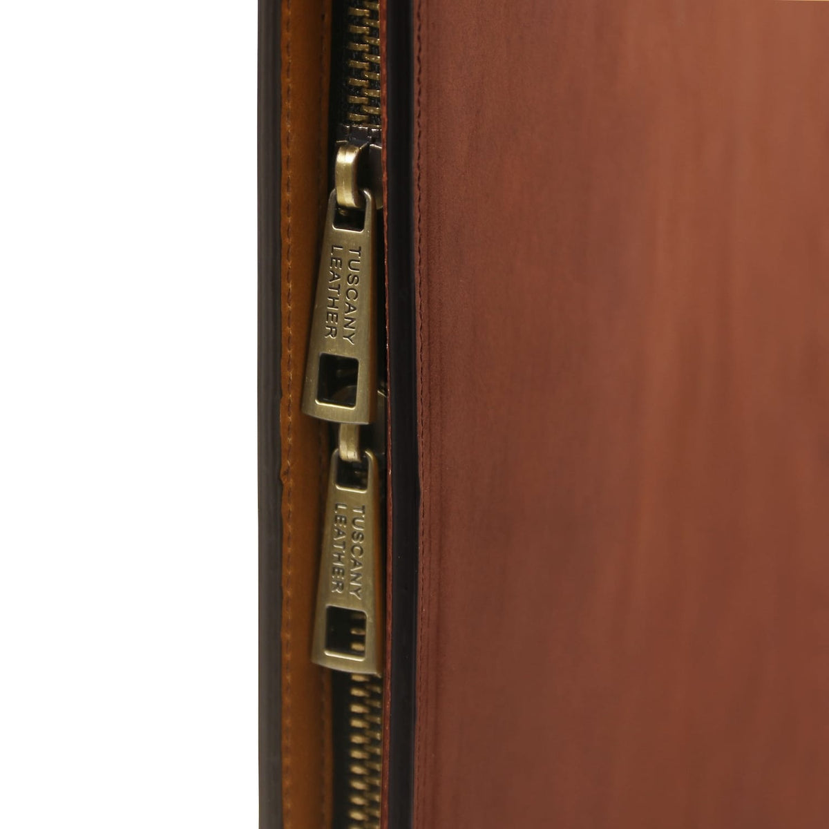 Grande plano of gold-tone zipper on the leather case with TUSCANY LEATHER pulls