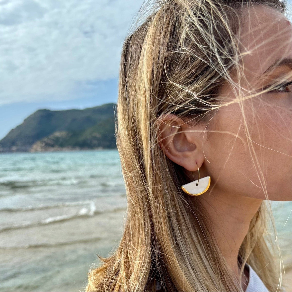 Bianco ceramic crescent dangle earrings con gold edges on a slim hoop ear wire