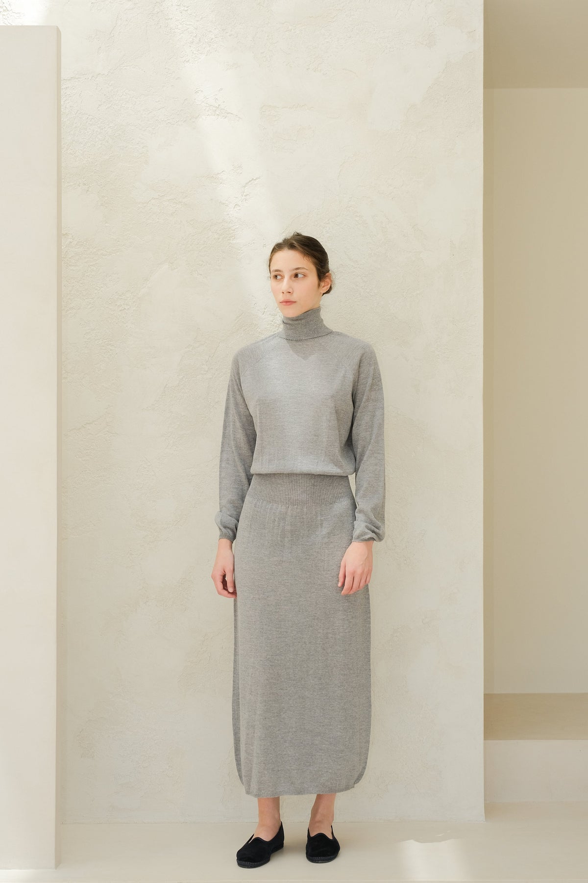 Model in grey turtleneck and matching knit skirt from the Extra Fine Merino Wool Dress collection.