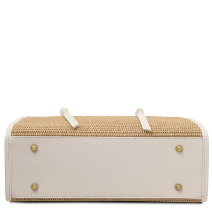 Bottom view of Frame straw effect bag showing white leather base with gold studs